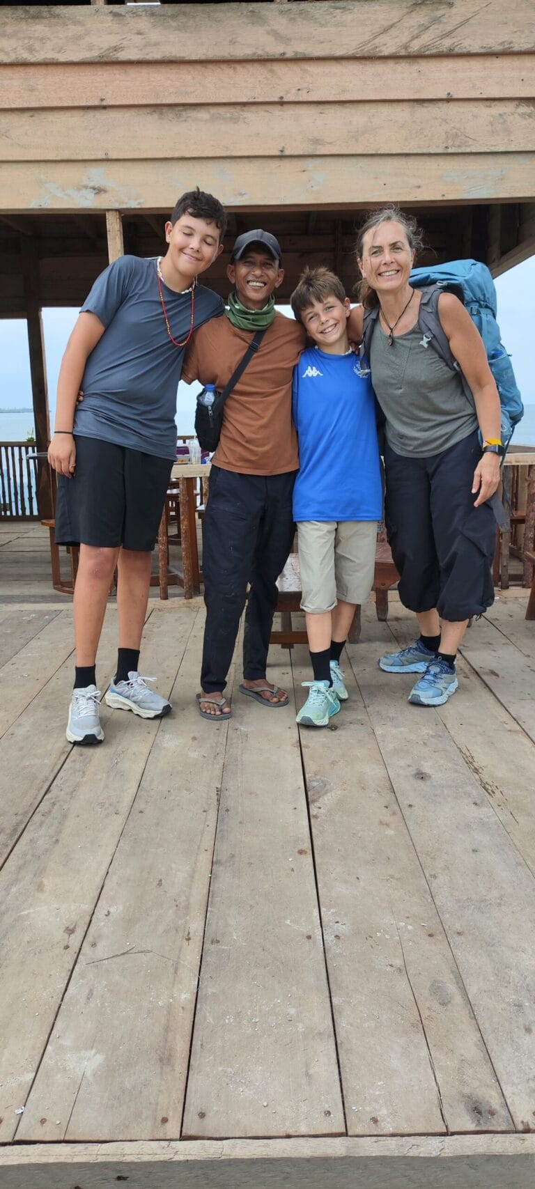 Andrian Salis posing with a guest family after completing a Mentawai tribe tour in Siberut