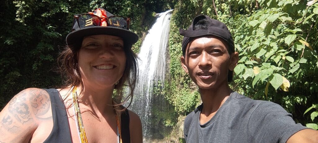 Tour guest and local guide taking a selfie together at a Siberut jungle waterfall