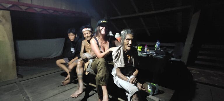 Tour guest in an evening portrait with Mentawai Sikerei elders in Siberut