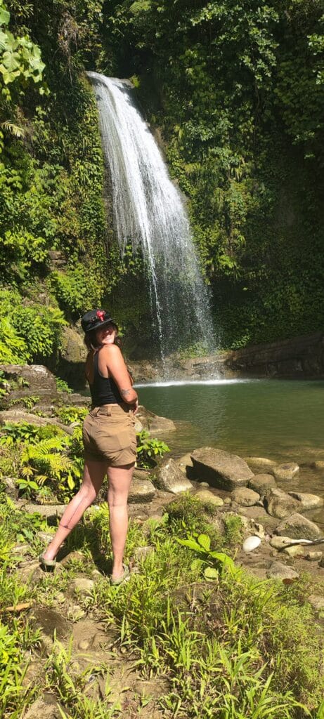 Tour guest posing at a jungle waterfall during a Mentawai tour in Siberut