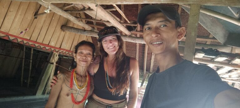 Tour guest taking a selfie with a Mentawai woman and their local guide in Siberut