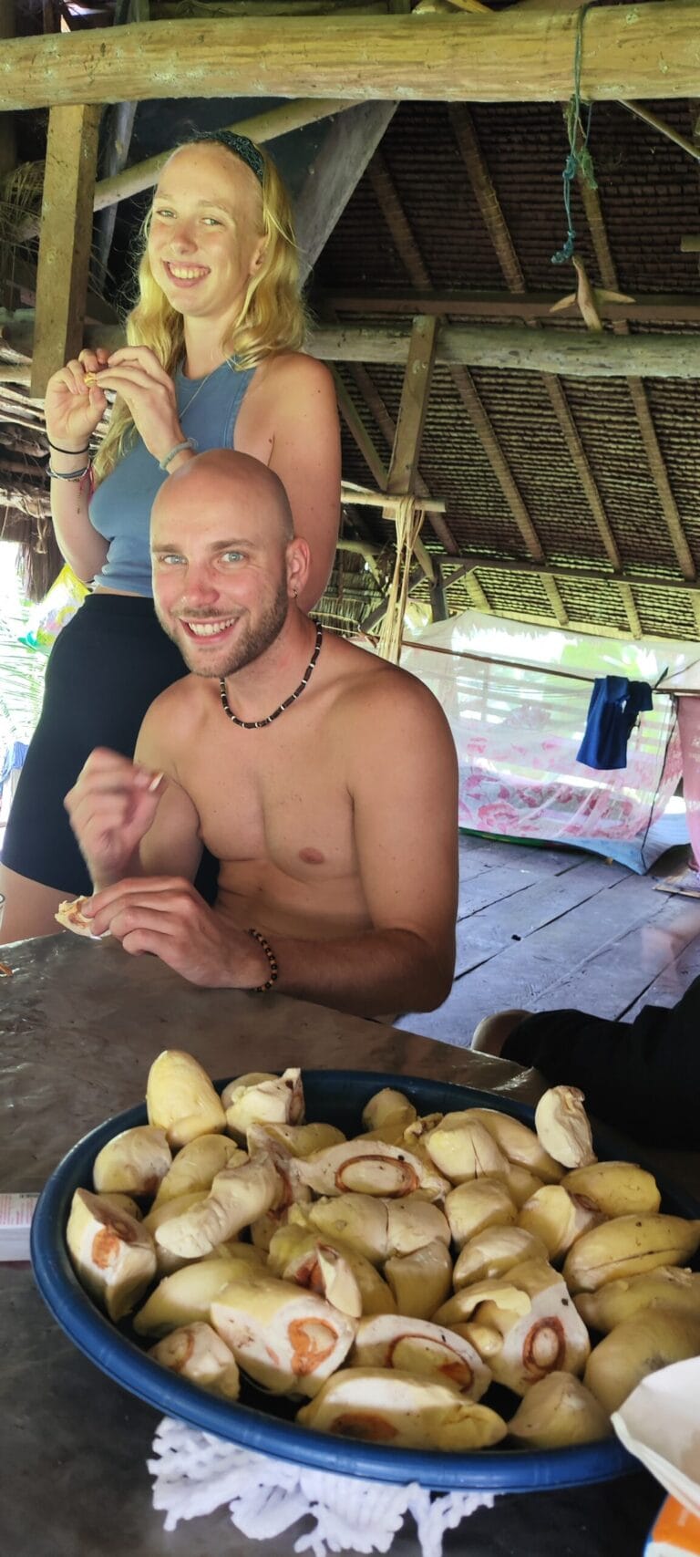 Tour guests eating fresh tropical fruit in a Mentawai village in Siberut