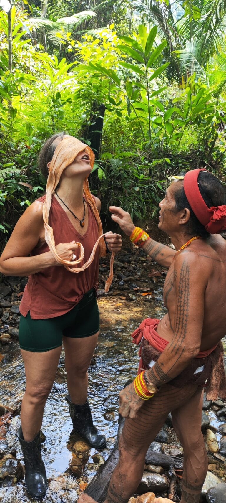 Tour guests sharing a laugh with a Mentawai Sikerei after crafting traditional tree bark clothing in Siberut