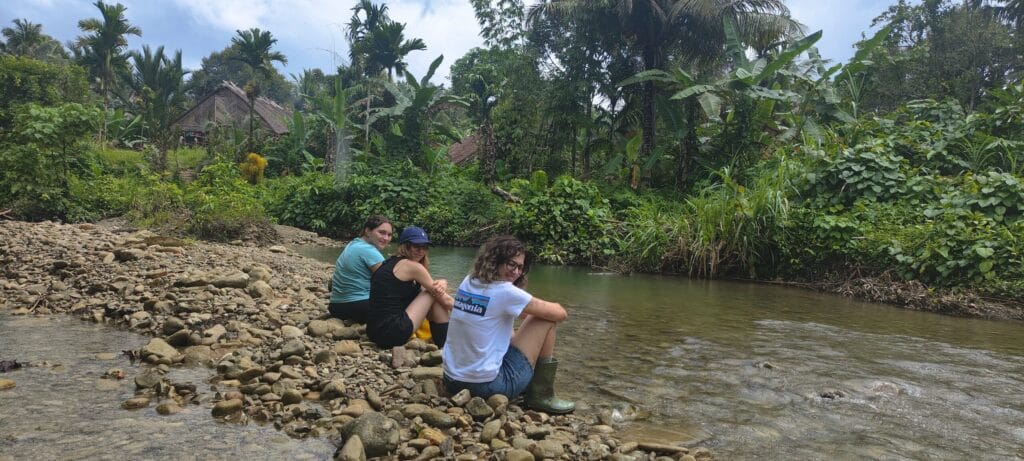 Tour guests relaxing by the river in a Mentawai village in Siberut