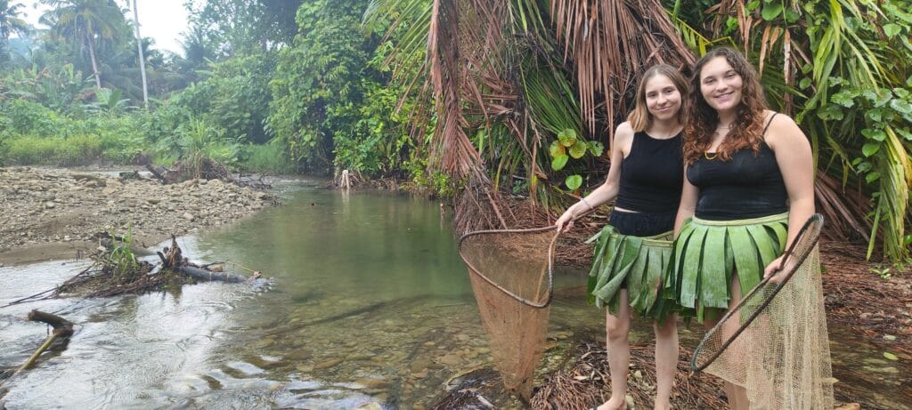 Tour guests wearing traditional Mentawai skirts while river fishing in Siberut
