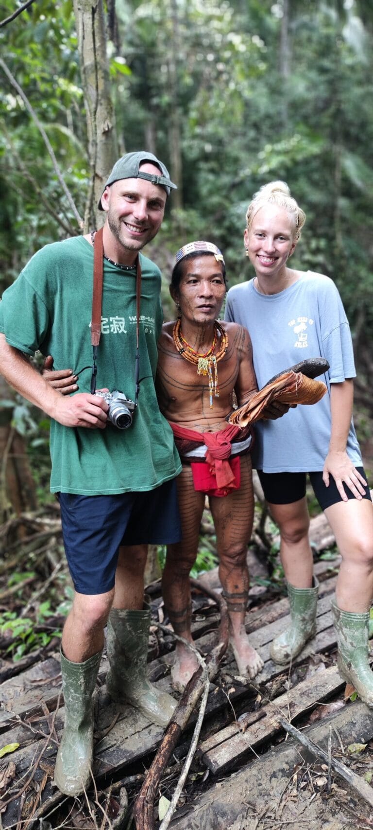 Tour guests with a Mentawai Sikerei holding traditional bark cloth in the Siberut jungle