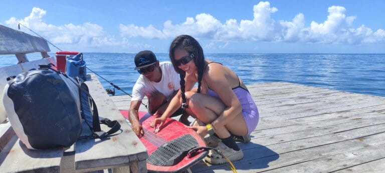 Local guide and surf guest checking a surfboard at the dock in Mentawai