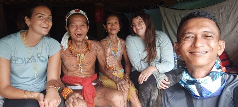 Andrian Salis with guests Olivia and Nam from the UK alongside a Mentawai Sikerei shaman and his wife in Siberut village