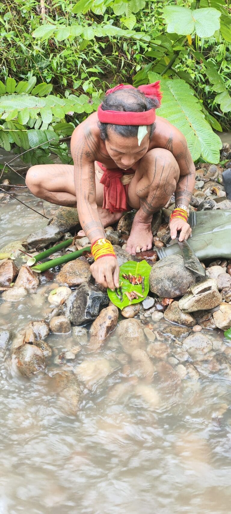 Mentawai Sikerei mixing traditional natural ingredients by the river in Siberut