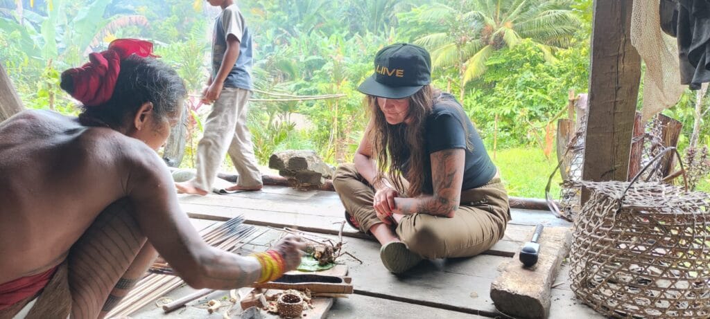Mentawai Sikerei preparing natural arrow poison ingredients with a tour guest in Siberut