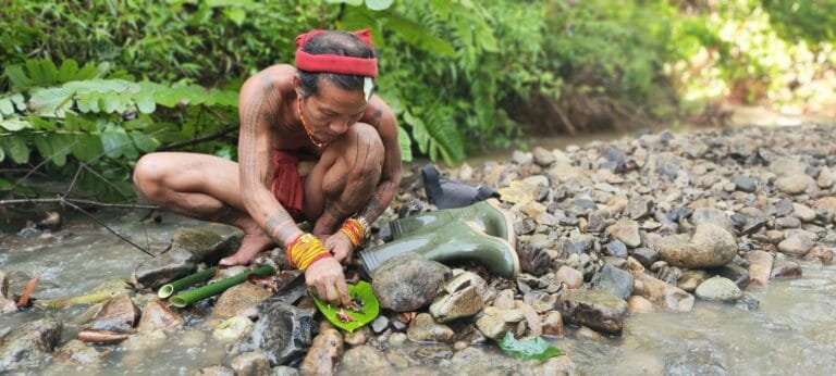 Mentawai Sikerei preparing natural forest ingredients by the riverside in Siberut
