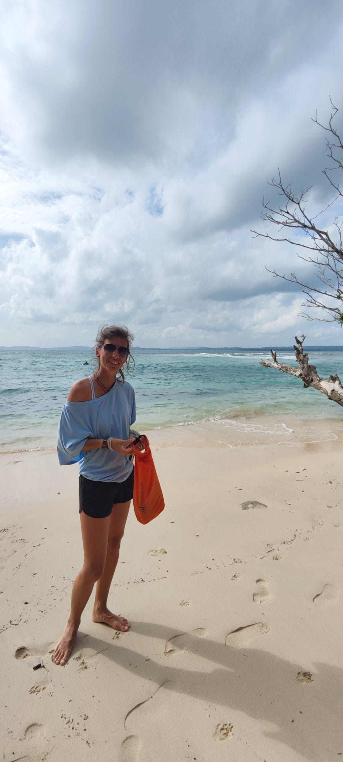 Tour guest relaxing on a white sand beach in the Mentawai Islands