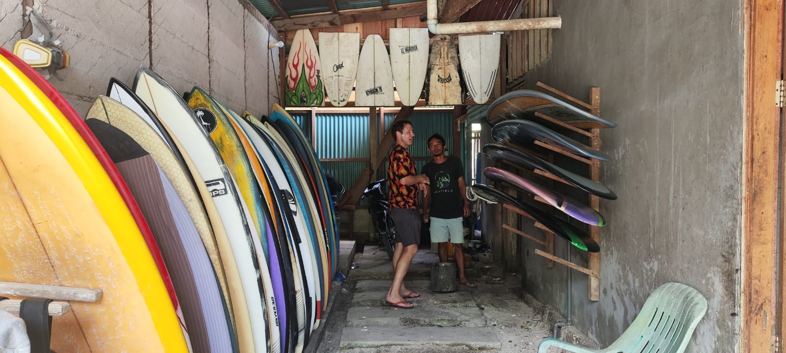 Guest selecting a surfboard with staff, Mentawai surf camp rental room