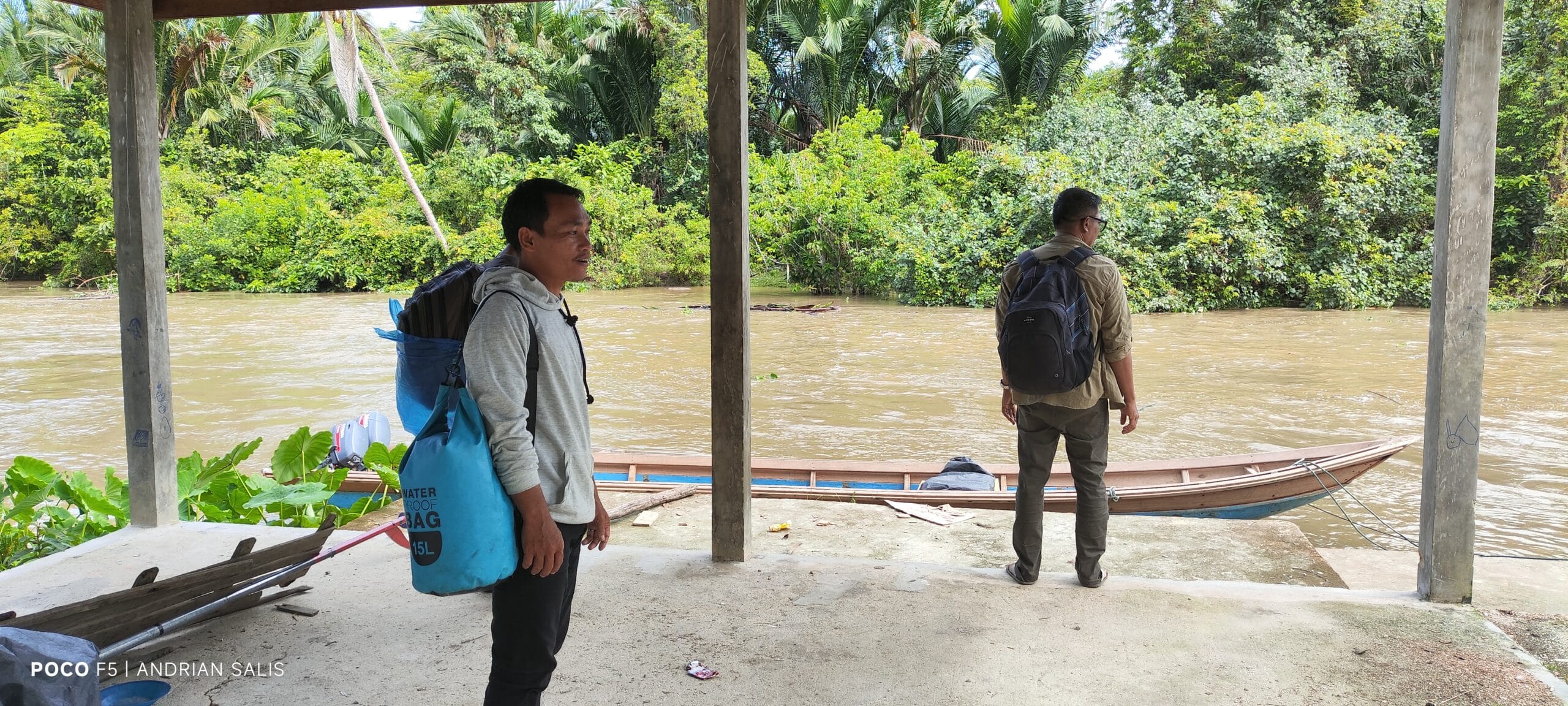 Local guide and tour guest waiting for a river boat in Siberut