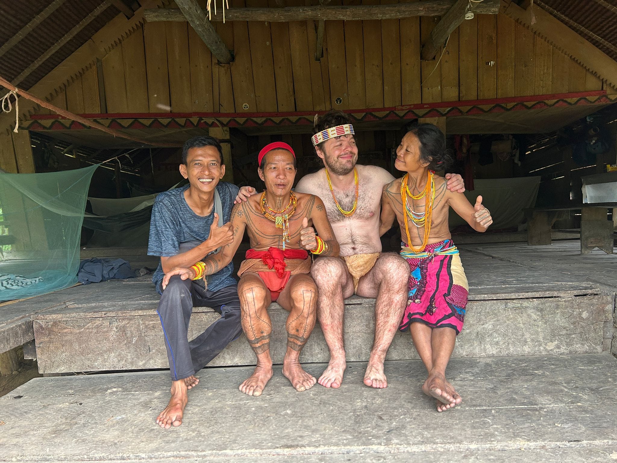 Guide and guest with Sikerei couple, group portrait inside Uma