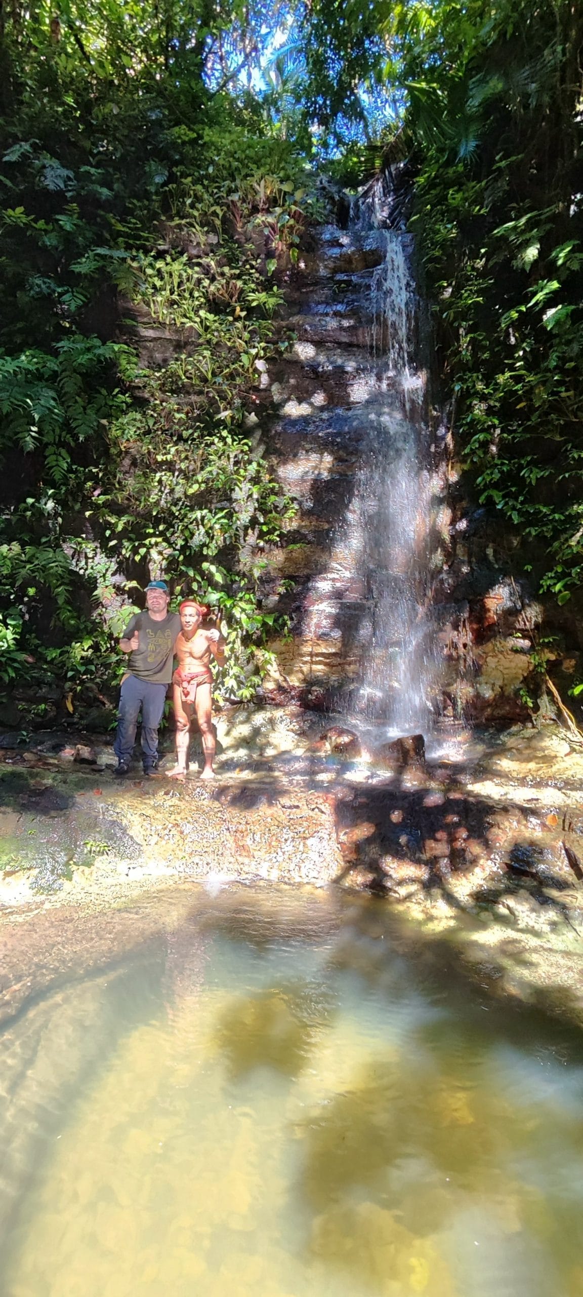 Sikerei and guest at a natural waterfall pool, Mentawai jungle