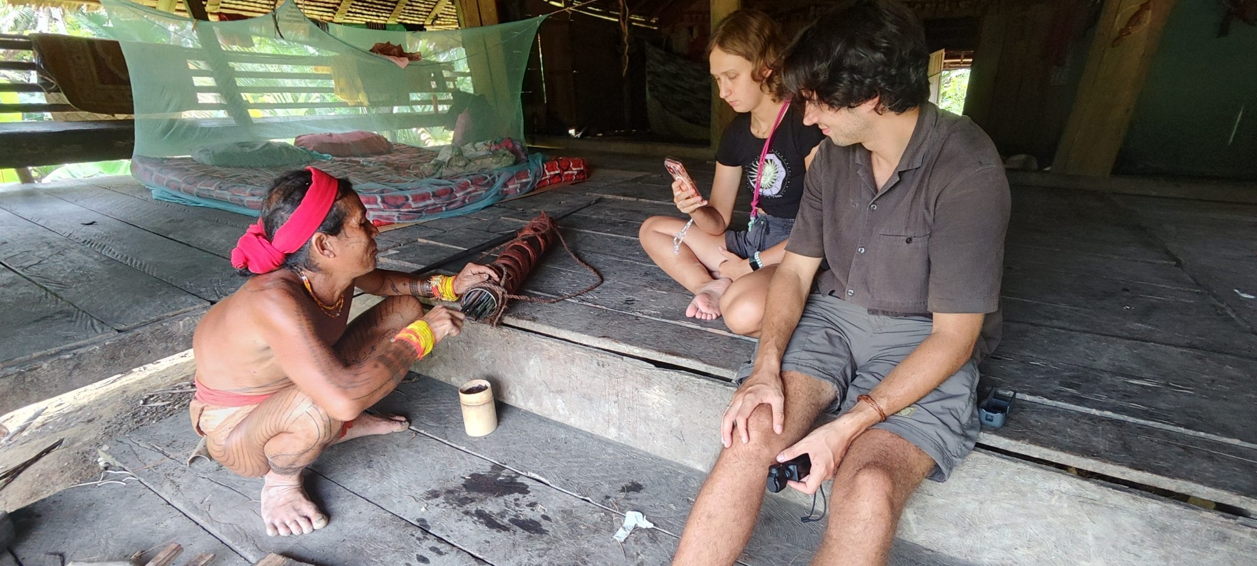 Sikerei preparing arrow poison while guests watch, Mentawai