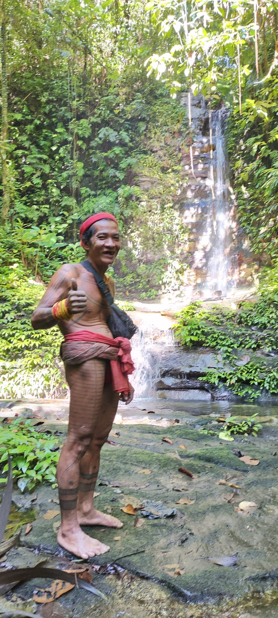 Sikerei giving a thumbs up at a hidden jungle waterfall, Mentawai